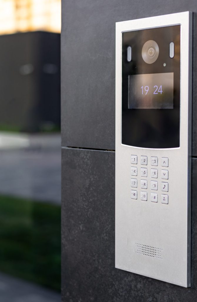 Entrance doorbell in a multi-apartment building, with a video surveillance camera, on a dark wall Entrance doorbell in a multi-apartment building, with a video surveillance camera, on a dark wall.